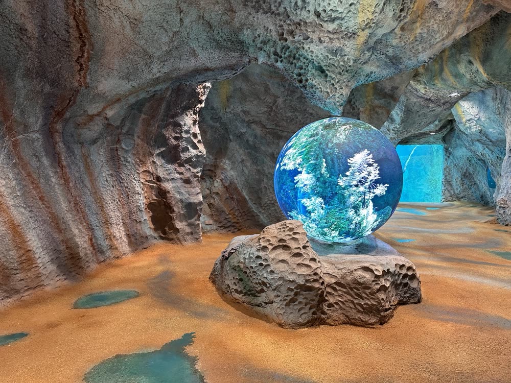 SPHERE-Installation in einer Grotte, Kugel zeigt einen winterlichen Wald
